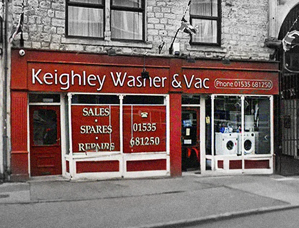 The dark red Keighley Washer & Vac shopfront on Low Street, with Sales, Spares, Repairs and the phone number in the window, washing machines on display, and the Royal Arcade entrance next door.